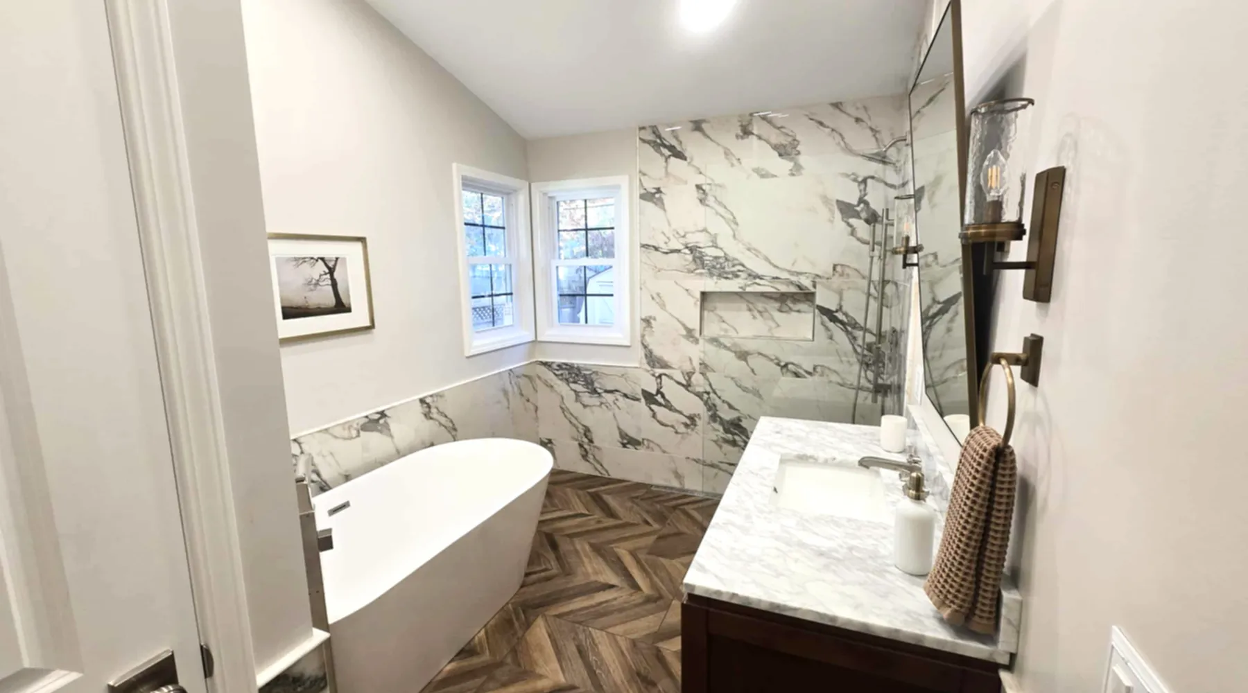 Freestanding tub against book-matched marble