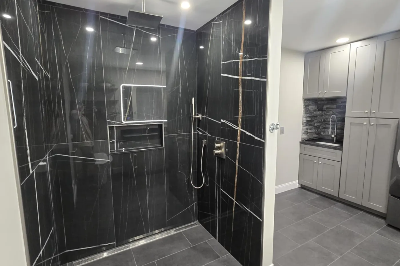 Slab-look black porcelain shower with LED-lit niche