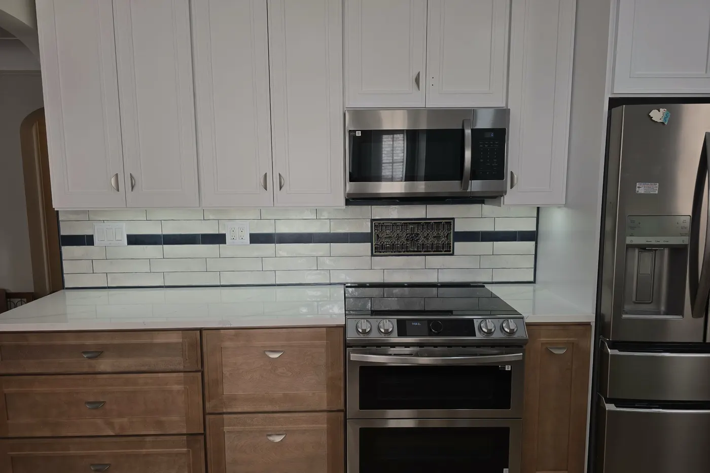 White shaker uppers, wood-tone lowers, subway backsplash
