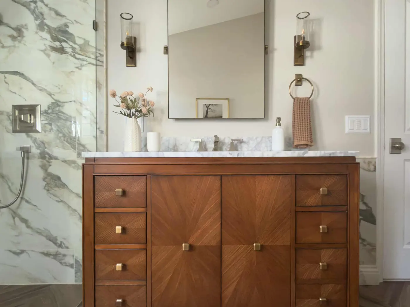 Book-matched marble walls, custom wood vanity, herringbone floor
