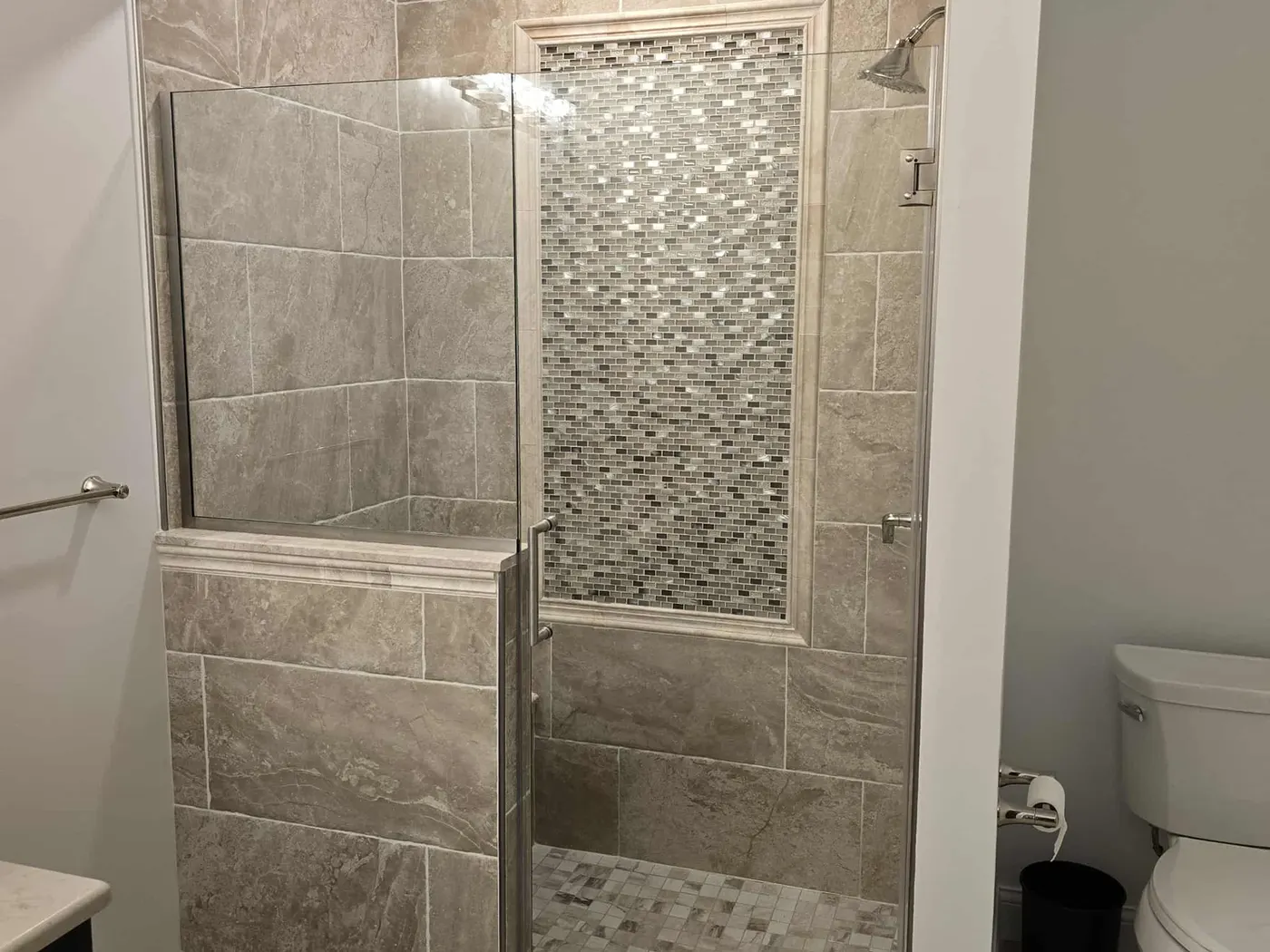 Grey tile with a vertical mosaic accent column
