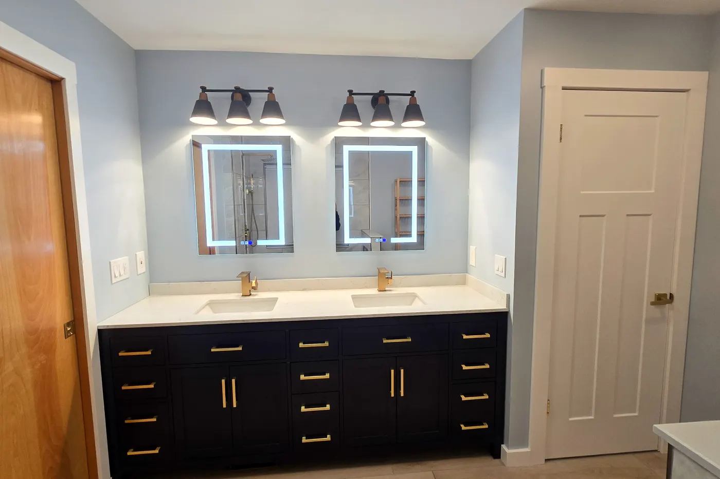 Navy double vanity, brass pulls, LED mirrors