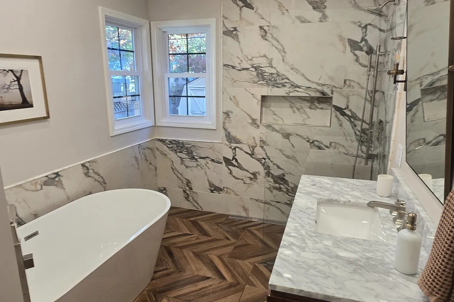 After: freestanding tub, marble-look walls and herringbone floor