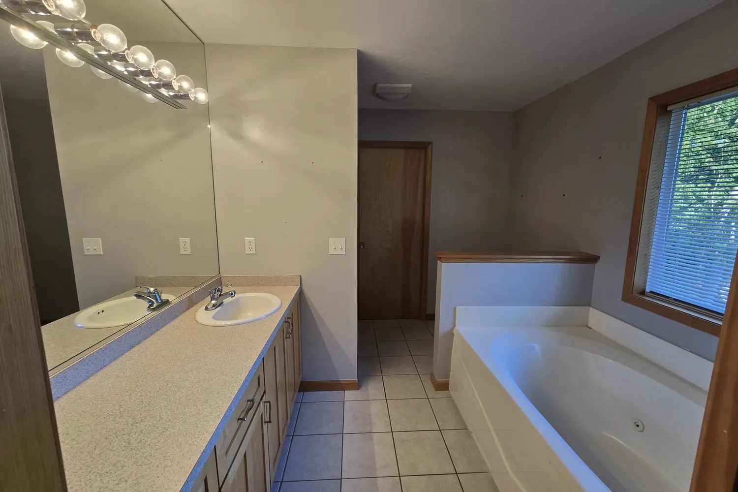 Before: the 1990s Wixom bathroom with almond vanity and drop-in tub