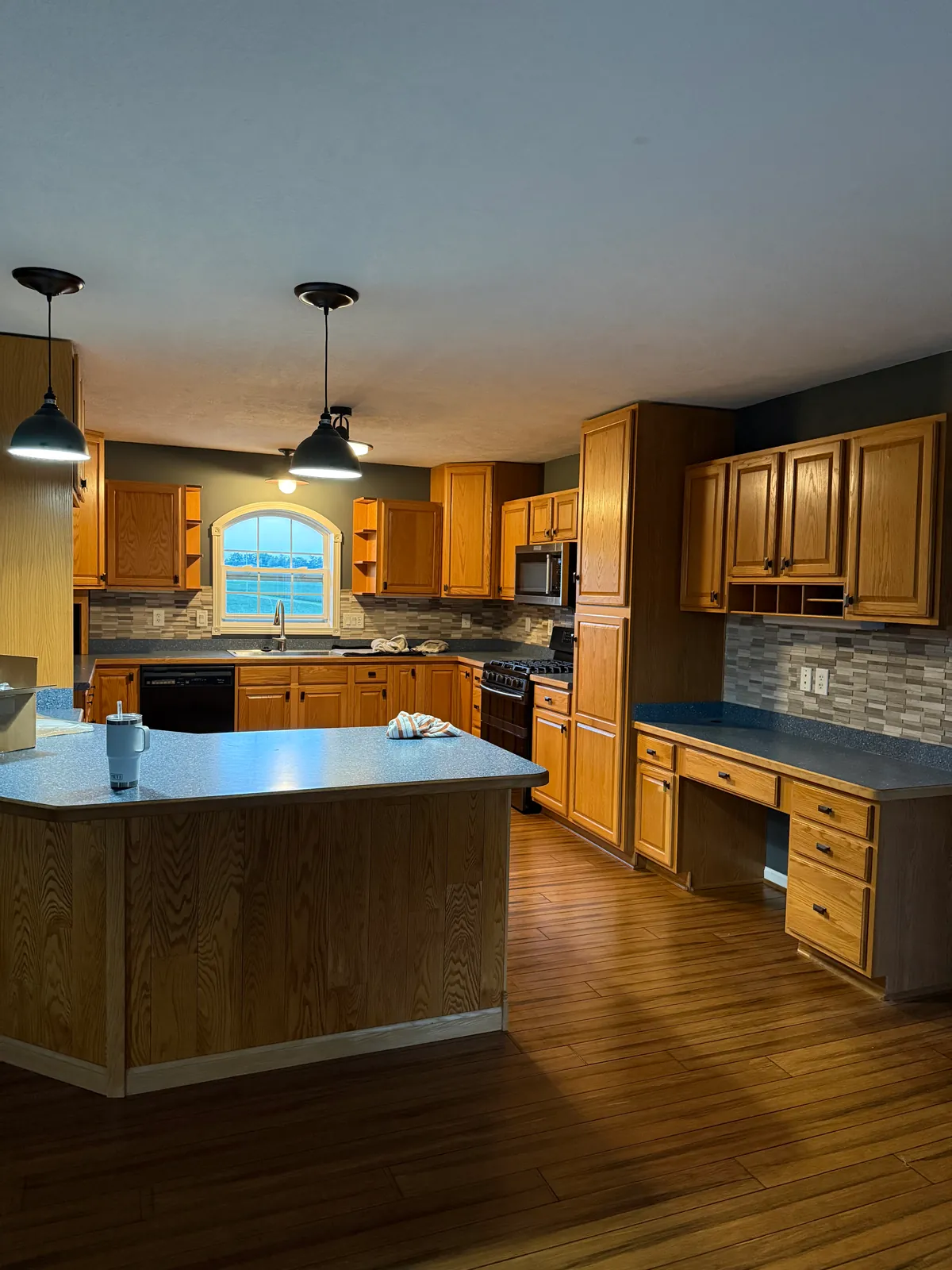 Before: oak cabinets along the range wall and the built-in desk