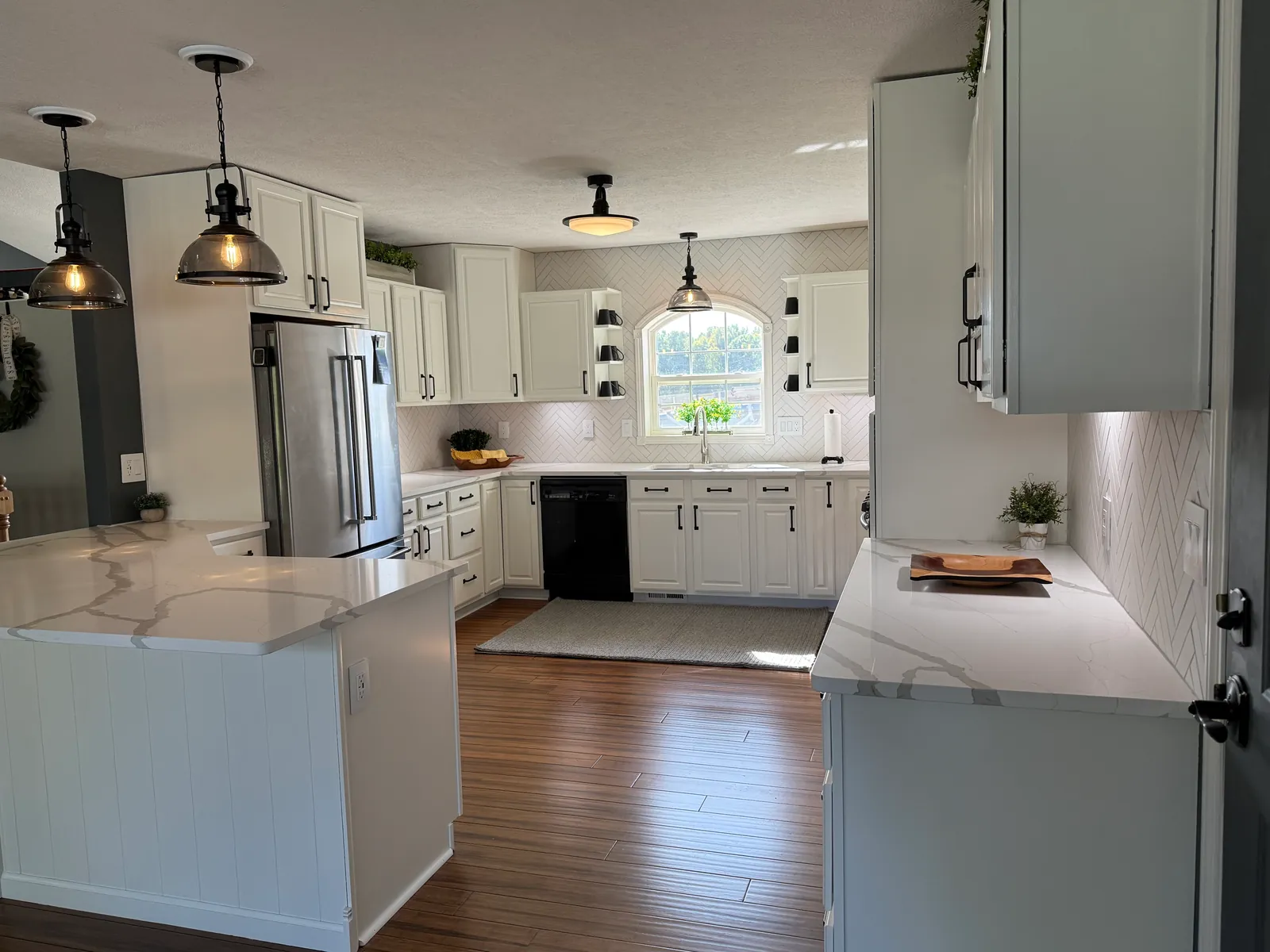 Finished: the kitchen from the doorway, white cabinets and herringbone tile