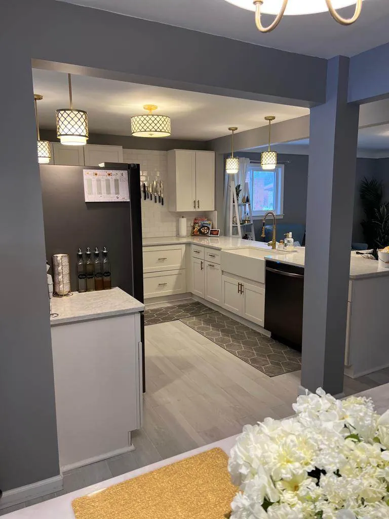 The finished Garden City kitchen with island, farmhouse sink and pendant lighting