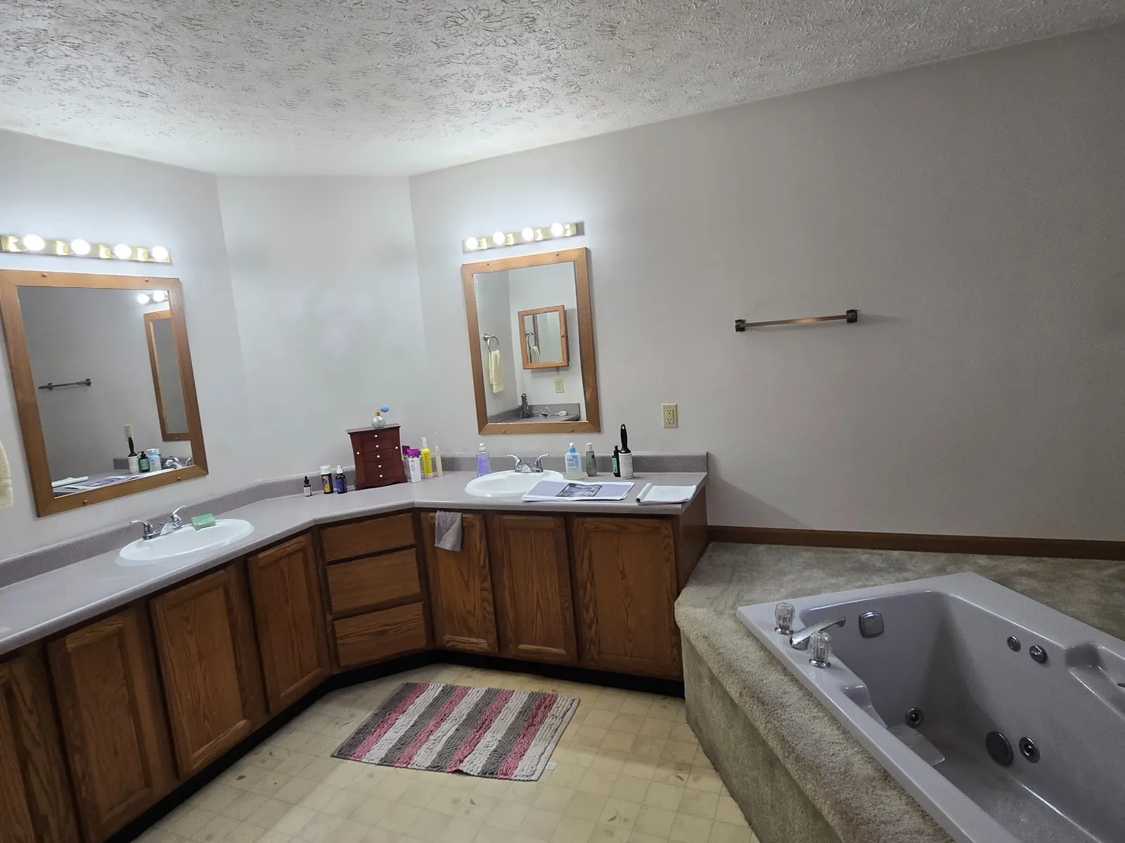 Before: oak corner double vanity and hollywood lighting