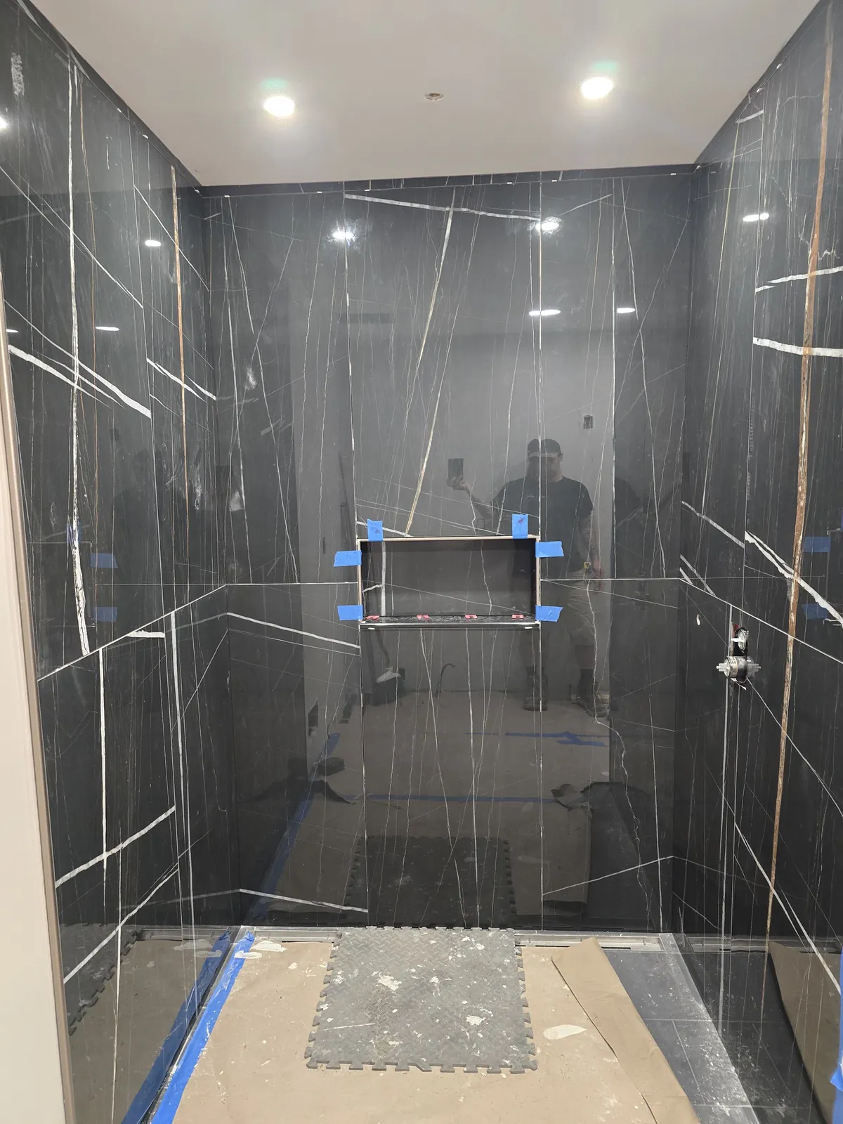 The slab shower mid-build: niche cut, panels aligned