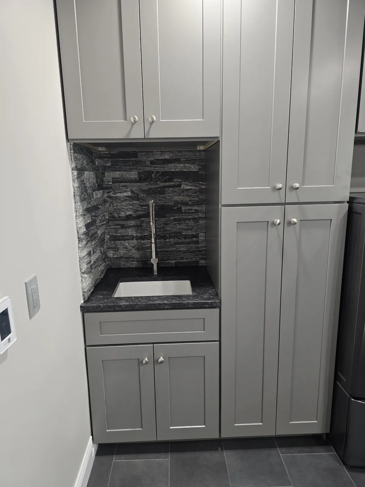 Finished utility sink with stacked stone accent