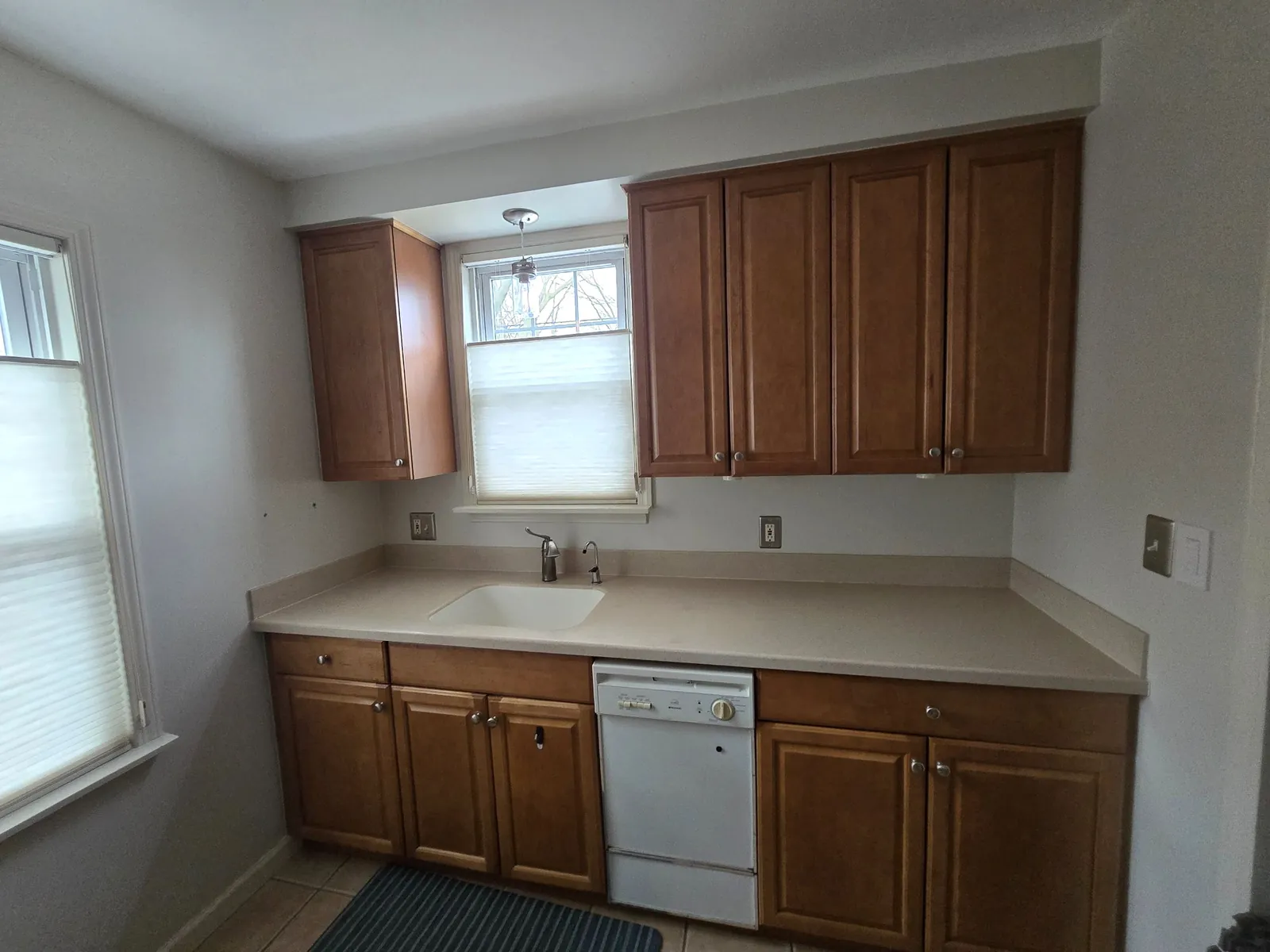 Before: oak cabinets and white appliances at the sink wall