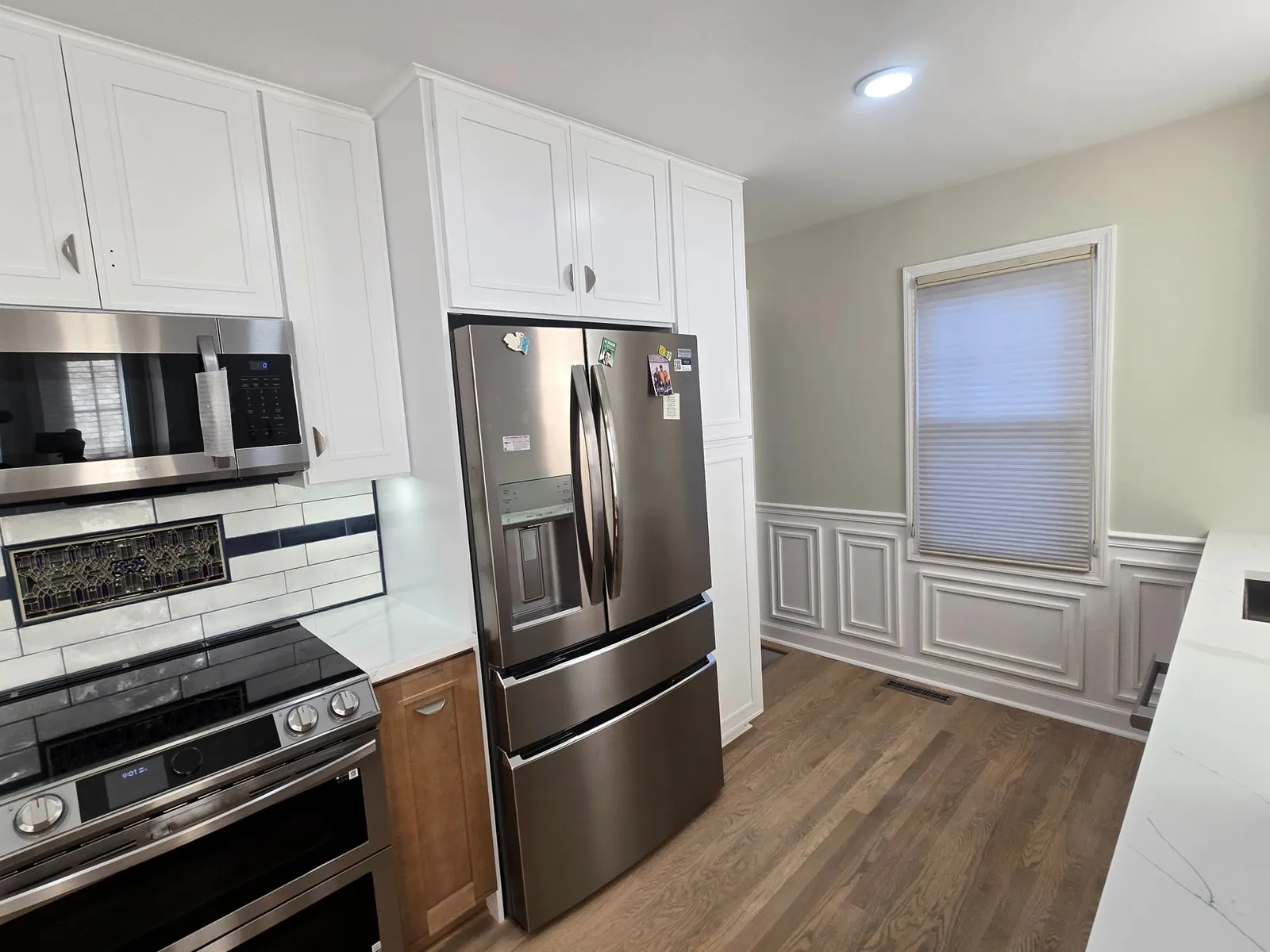 The finished Plymouth kitchen: two-tone cabinets, quartz and subway backsplash