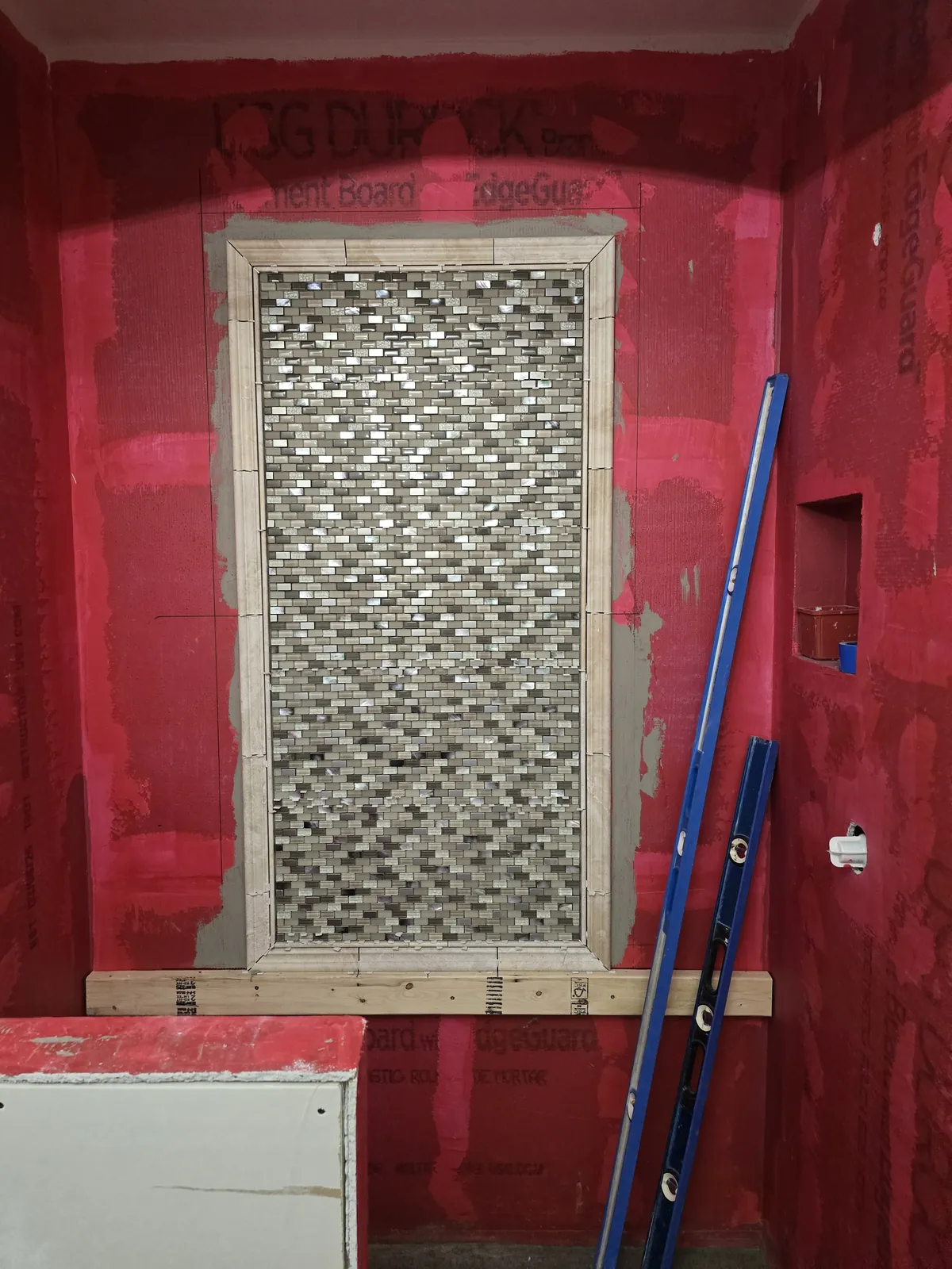 Completed waterproofing with niche and mosaic column ready for field tile