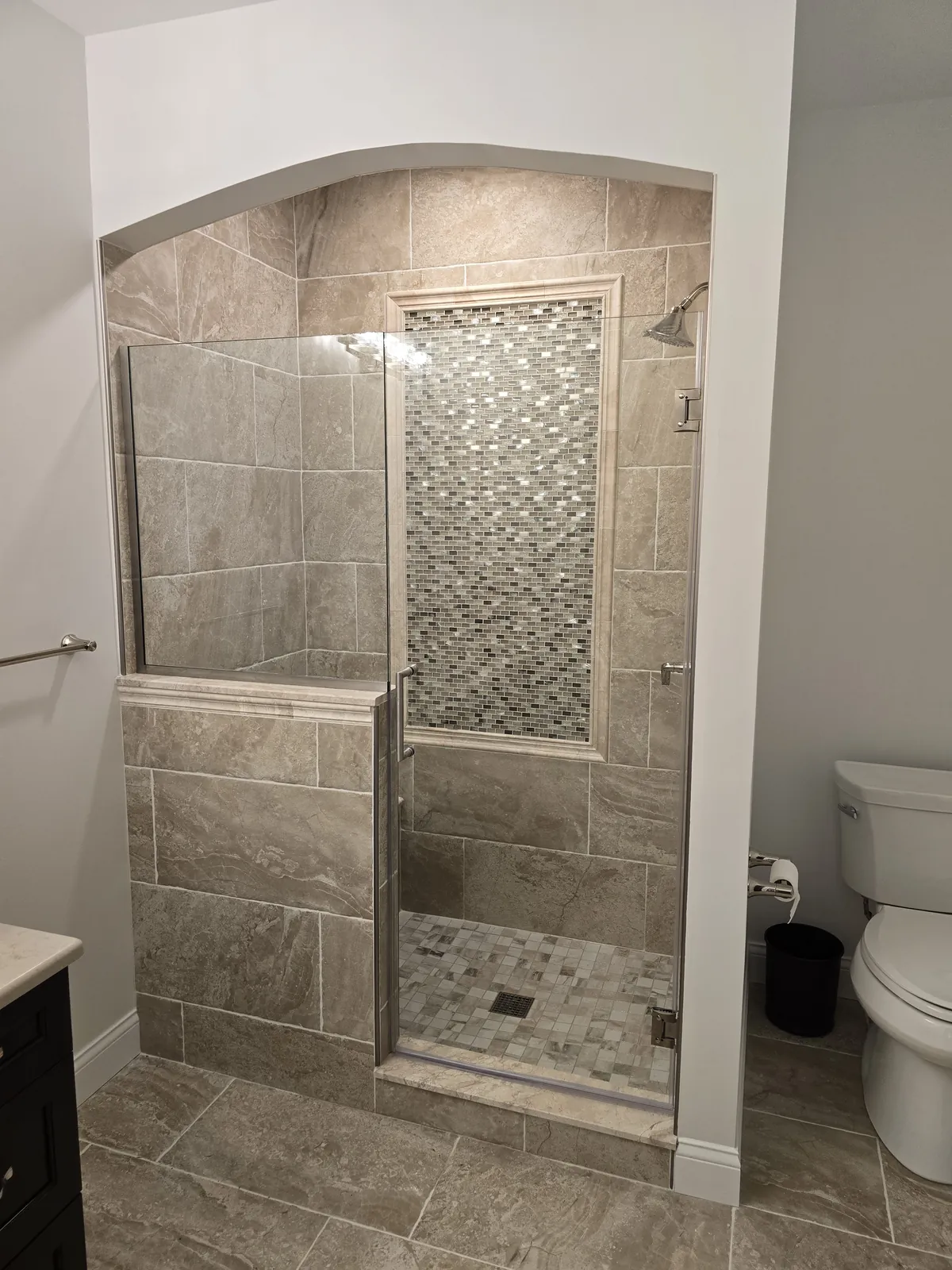 Finished: arched custom tiled shower with bench and mosaic accent column