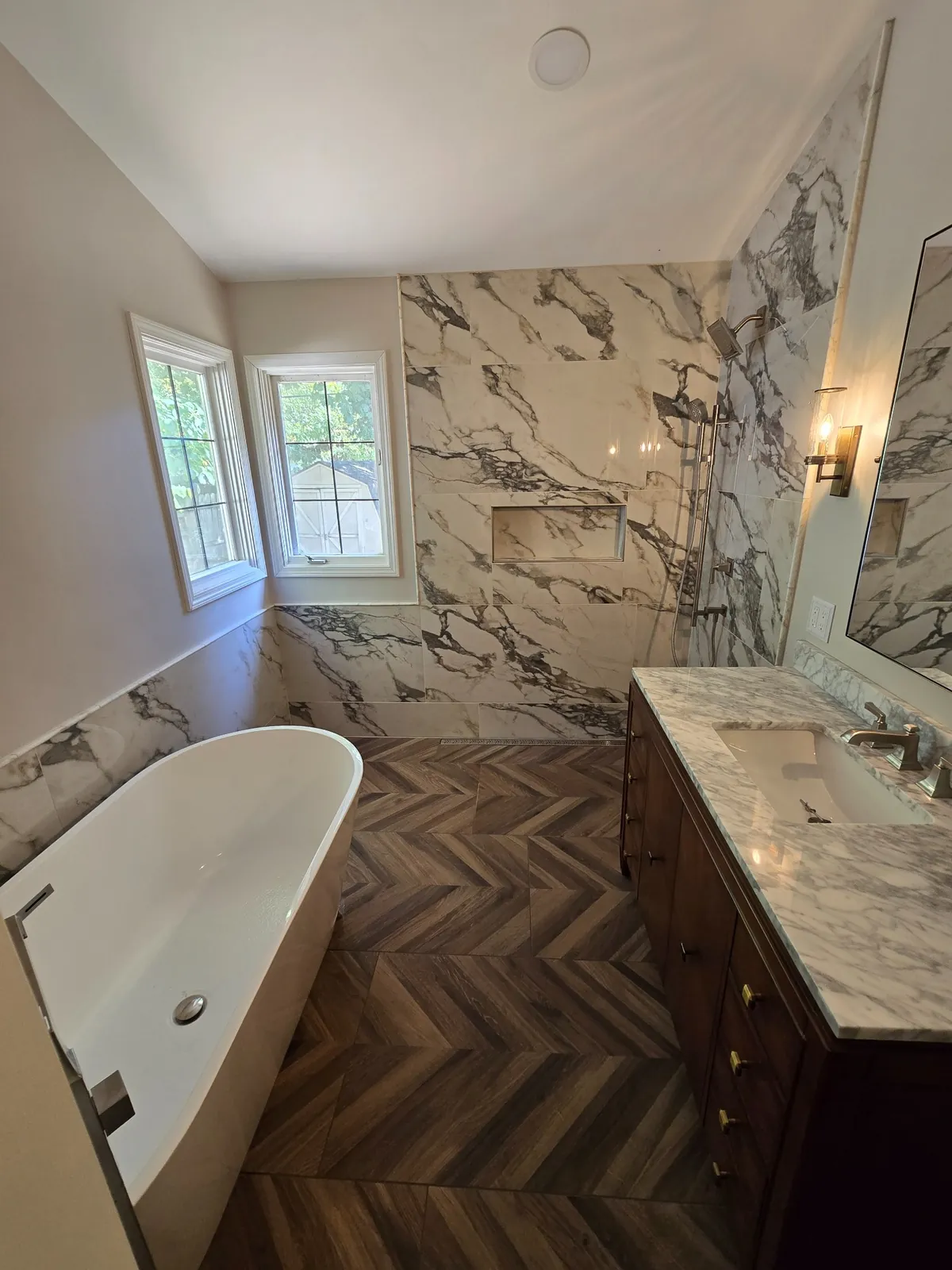 Finished: freestanding tub against book-matched marble-look walls
