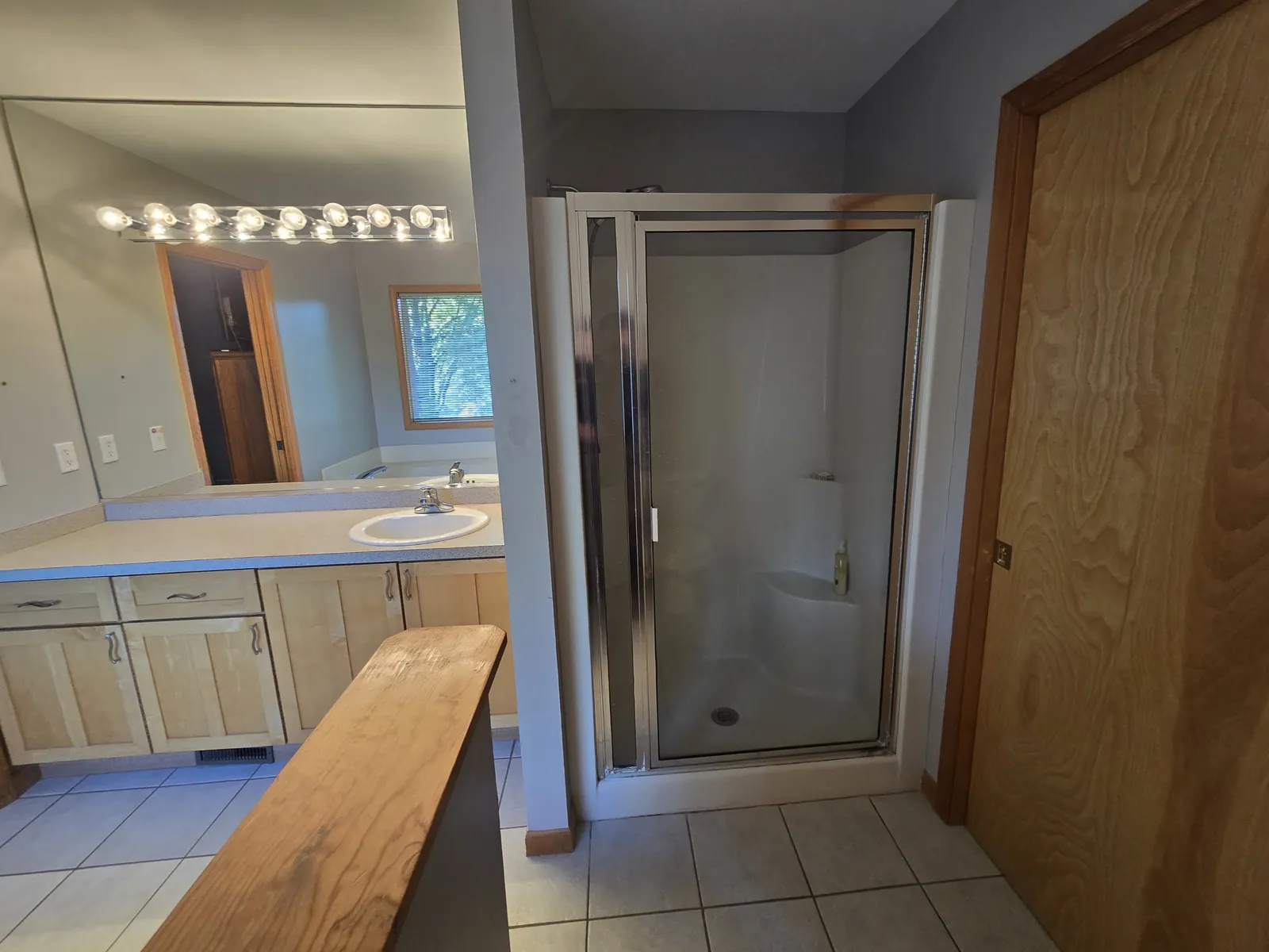 Before: the dated framed shower beside the vanity