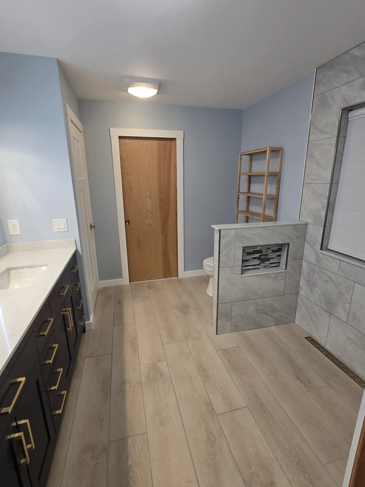 Wood-look flooring ties the finished bathroom together